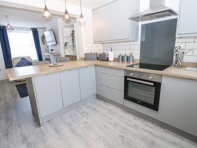 A kitchen with a countertop, oven, and sink at Keekle Terrace in Cleator Moor