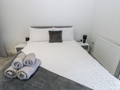 A bedroom with a bed and towels at Keekle Terrace in Cleator Moor