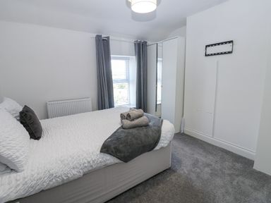 A bedroom with a bed and towels at Keekle Terrace in Cleator Moor