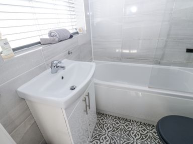 A bathroom featuring a sink and bathtub at Keekle Terrace in Cleator Moor