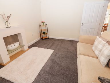 A living room with a sofa and a fireplace at Lingla House in Frizington