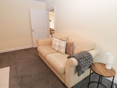 A living room with a sofa and side table at Lingla House in Frizington