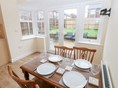A dining room with a table set for four at Lingla House in Frizington