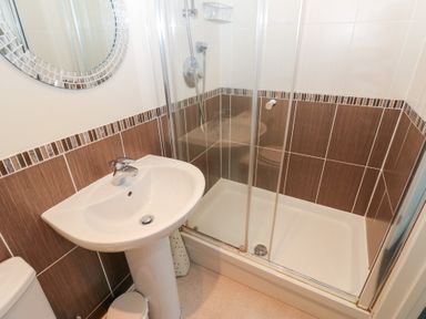 A bathroom with a shower and sink at Lingla House in Frizington