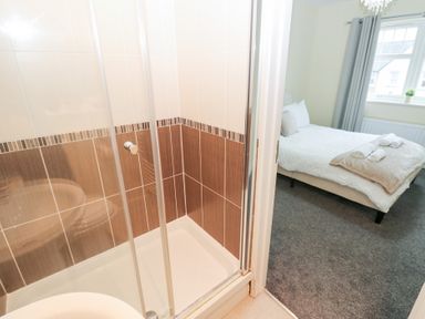 A bathroom with a shower and view of a bedroom at Lingla House in Frizington