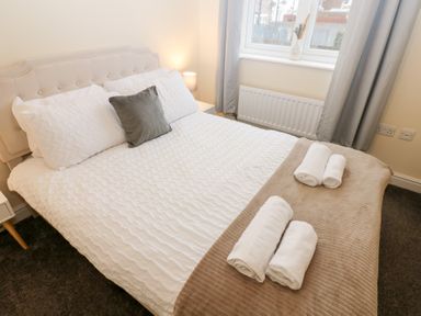 A bedroom with a bed and towels arranged at Lingla House Frizington