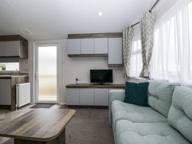 A living room with a couch and television at Puffin in St Bees