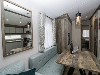A dining room with a table and sofa at Puffin in St Bees