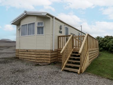 A mobile home with wooden steps in St Bees at Puffin