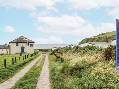 A coastal path leading to a building near the sea at Puffin in St Bees