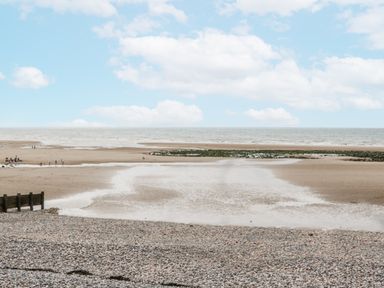 A beach view with clouds and a tidal area at Puffin St Bees