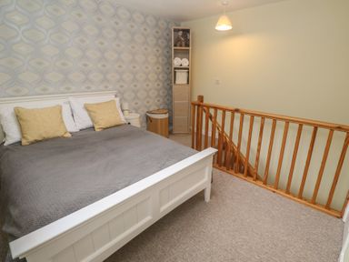 A bedroom with a bed and storage unit at Mini Mena in St Austell