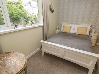 A bedroom with a bed and decorative elements at Mini Mena in St Austell