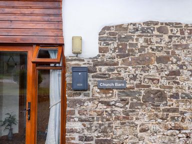 Exterior view of Church Barn with window and stone wall in Sutcombe near Bradworthy