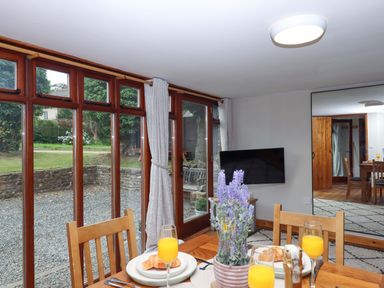 A dining room with a table set for breakfast at Church Barn Sutcombe near Bradworthy
