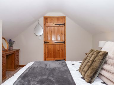 A bedroom with a bed and dresser at Church Barn Sutcombe near Bradworthy