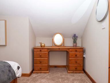 A bedroom with a wooden desk and mirror at Church Barn in Sutcombe near Bradworthy