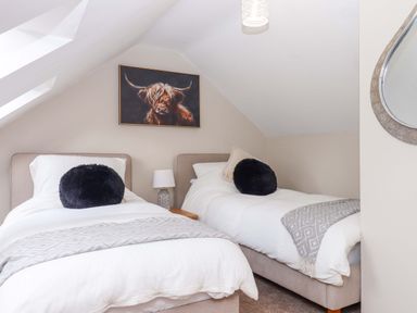 A bedroom with two beds and a painting at Church Barn Sutcombe near Bradworthy