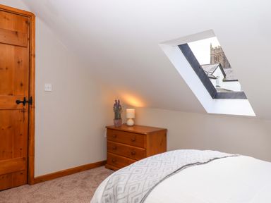 A bedroom with a window and furniture at Church Barn Sutcombe near Bradworthy
