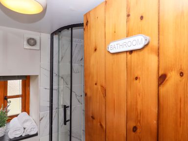 A bathroom with a shower and towels at Church Barn Sutcombe near Bradworthy
