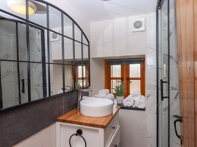 A bathroom with a sink and towels at Church Barn in Sutcombe near Bradworthy