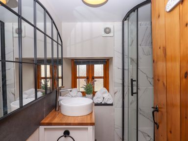 A bathroom with a sink and shower at Church Barn in Sutcombe near Bradworthy