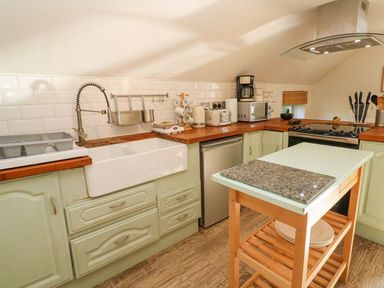 A kitchen with countertop, sink, and appliances at Five Elements Barn in Truro