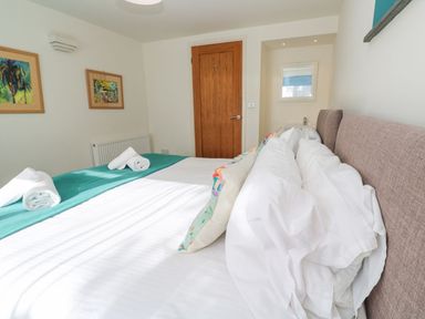 A bedroom with a bed and framed paintings at Five Elements Barn in Truro