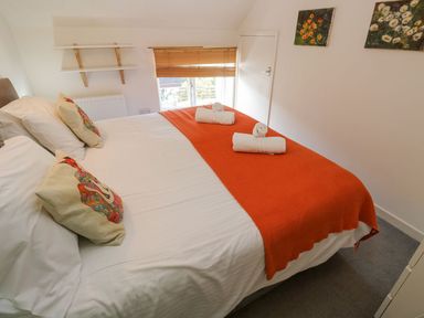 A bedroom with a bed and towels at Five Elements Barn in Truro