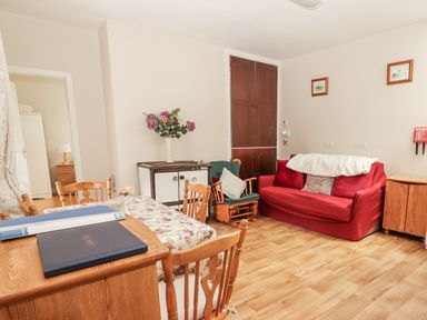 A living room with a sofa and table at Kate's Cottage