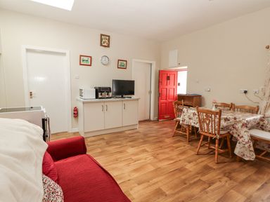 A living room with a table and chairs at Kate's Cottage