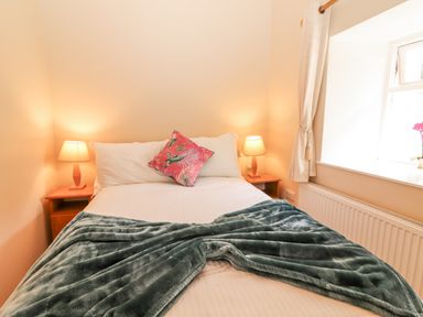 A bedroom with a bed and bedside tables at Kate's Cottage