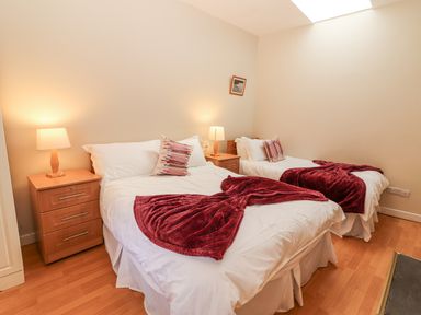 A bedroom with two beds and nightstands at Kate's Cottage