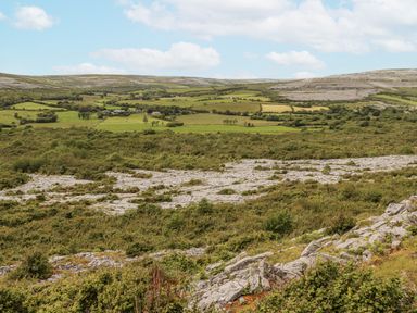 A landscape featuring hills and fields with rock formations in the distance at Kate's Cottage
