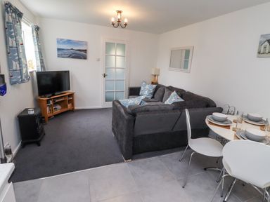 A living room with a sofa and dining table at 51 Longstone Park