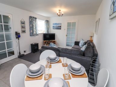 A living room with a sofa and dining table at 51 Longstone Park