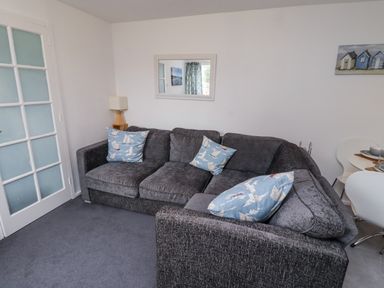 A living room with a sofa and lamp at 51 Longstone Park