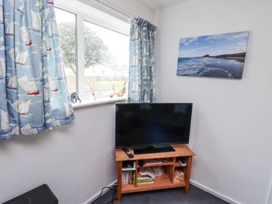 A living room with a television and window at 51 Longstone Park