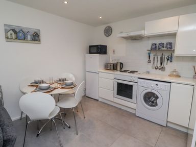 A kitchen with a dining table and appliances at 51 Longstone Park