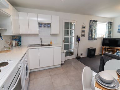 A kitchen with a sink, cabinets, and appliances at 51 Longstone Park