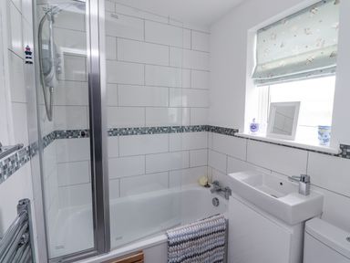 A bathroom with a shower and bathtub at 51 Longstone Park