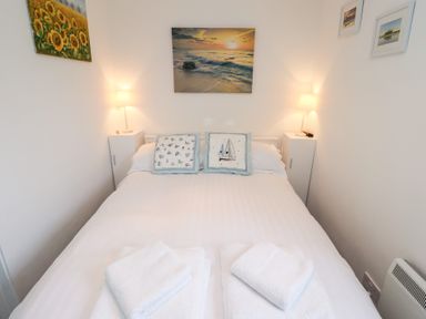 A bedroom with a bed and wall decorations at 51 Longstone Park Beadnell