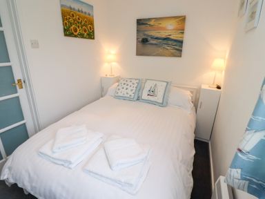A bedroom with a bed and artwork at 51 Longstone Park Beadnell