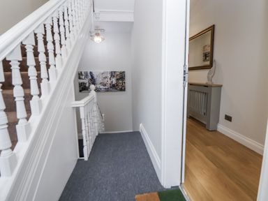 A hallway with a staircase and a console table at No 2 Emporium Apartments in Prestatyn