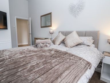 A bedroom with a bed and a mirror at No 2 Emporium Apartments in Prestatyn