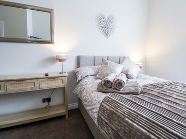 A bedroom with a bed and a console table at No 2 Emporium Apartments in Prestatyn