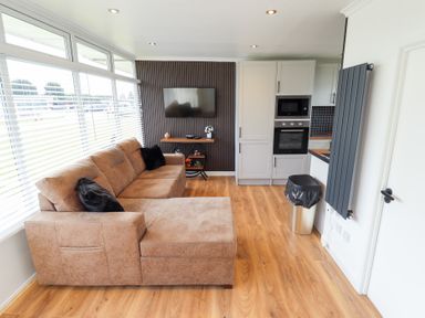 A living room with a sofa and television at 66 Cherry Park in Skegness
