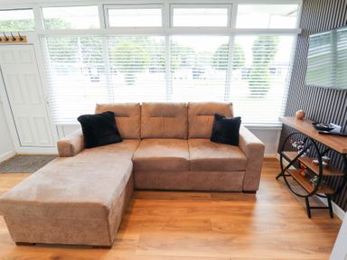 A living room with a sofa and a television at 66 Cherry Park Skegness