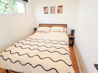 A bedroom with a bed and artwork at 66 Cherry Park in Skegness