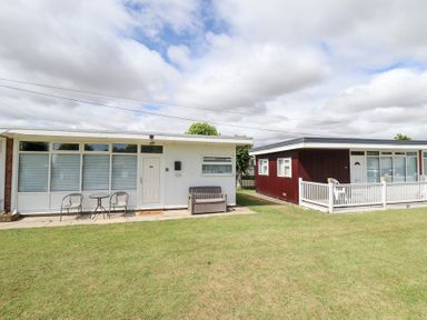 A house with a front entrance and outdoor seating at 66 Cherry Park Skegness
